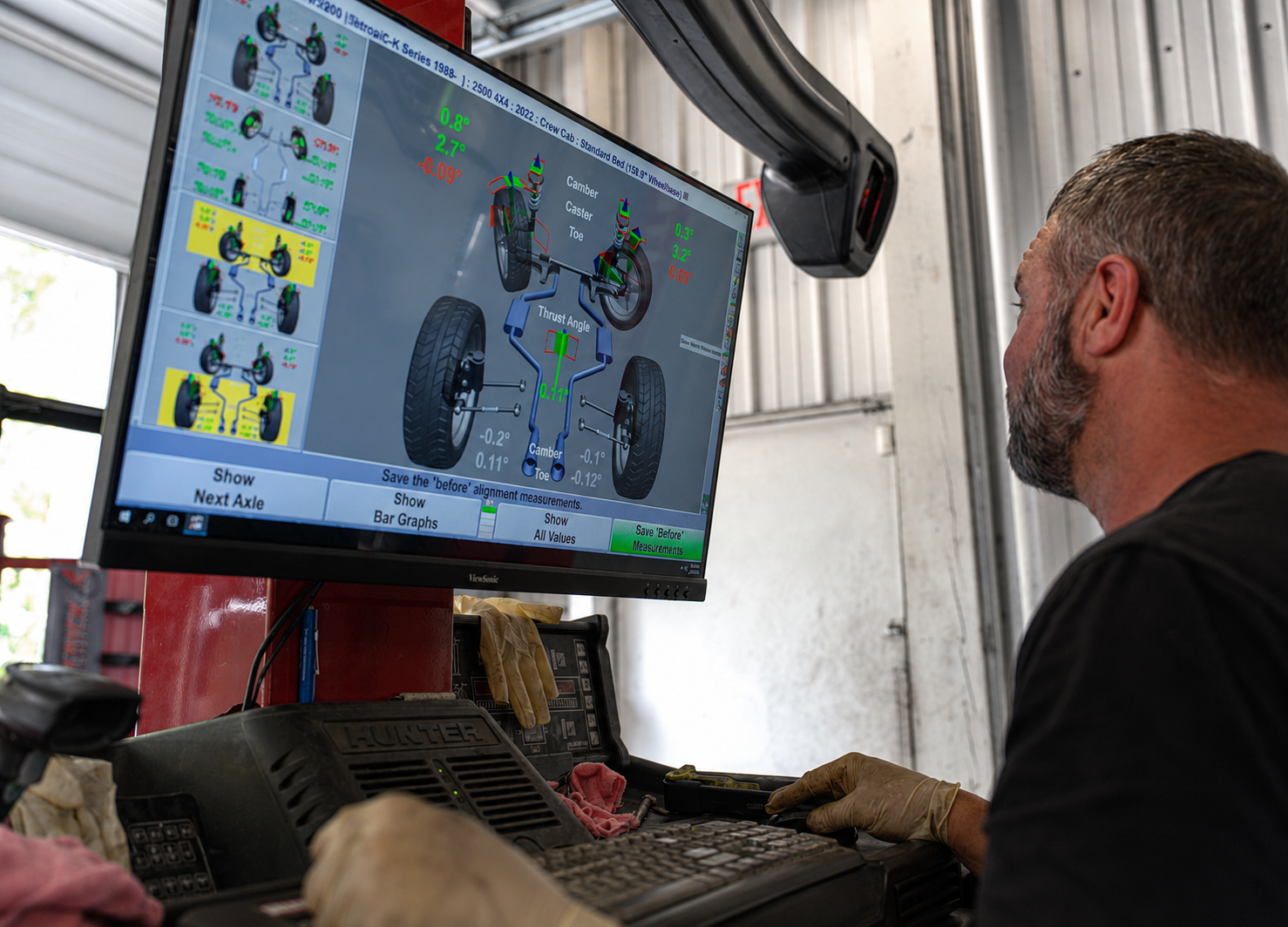 Choice Tire & Automotive technician reading alignment specs on the Hunter alignment rack